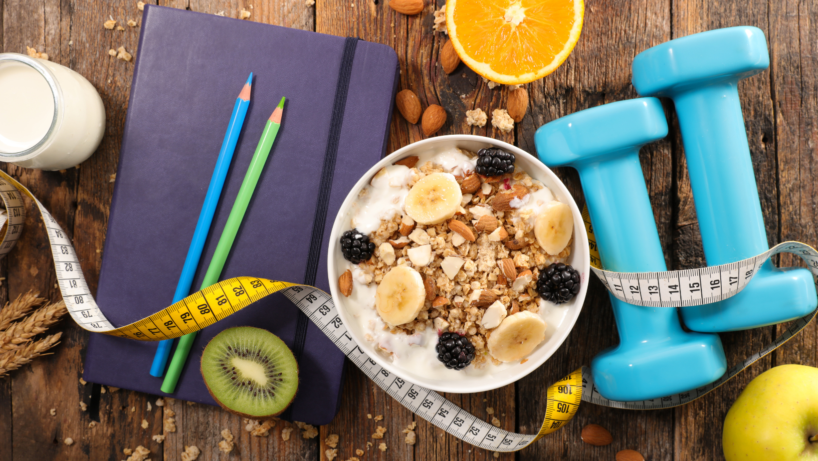 Ciotola di muesli con yogurt e frutta fresca, metro da sarta e manubri azzurri su un tavolo di legno